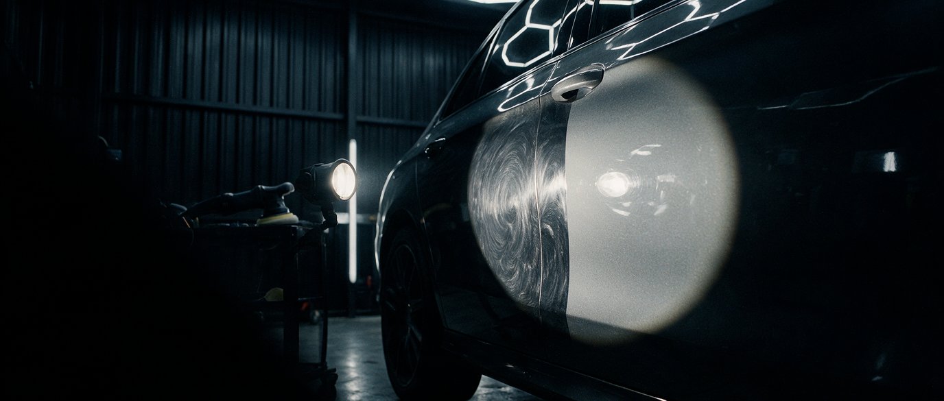 Swirl marks revealed under an inspection lamp, half corrected
